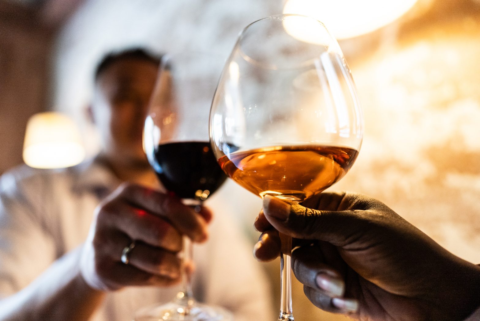 Close-up of couple toasting wine at restaurant