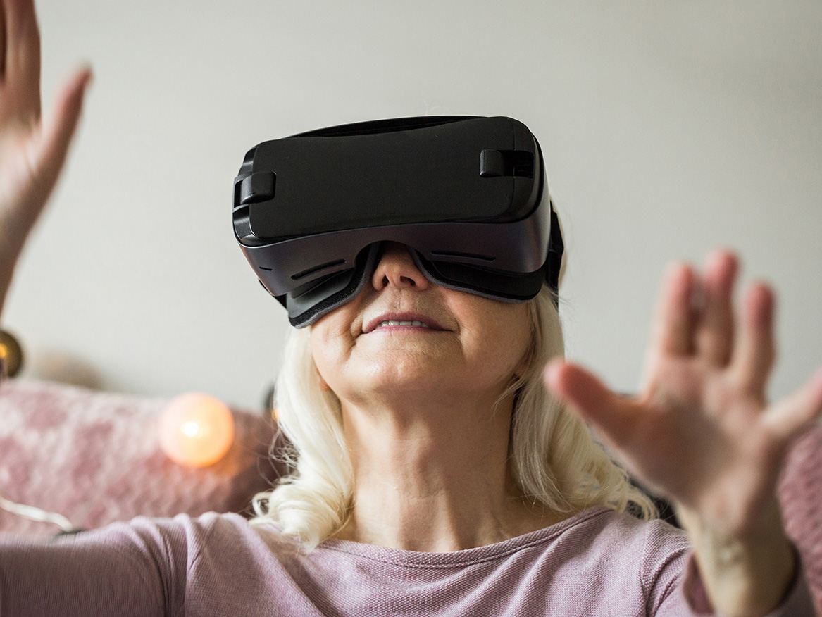 Portrait of happy senior woman having fun with virtual reality headset.
