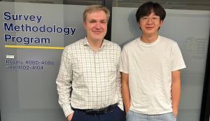 Henning Silber and Troy Liu standing in front of Survey Methodology Program sign.