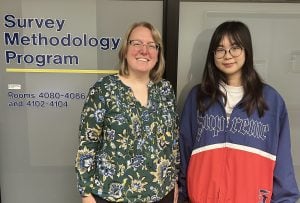 Sarah Patterson and Effy Tang standing in front of the Survey Methodology Program sign.