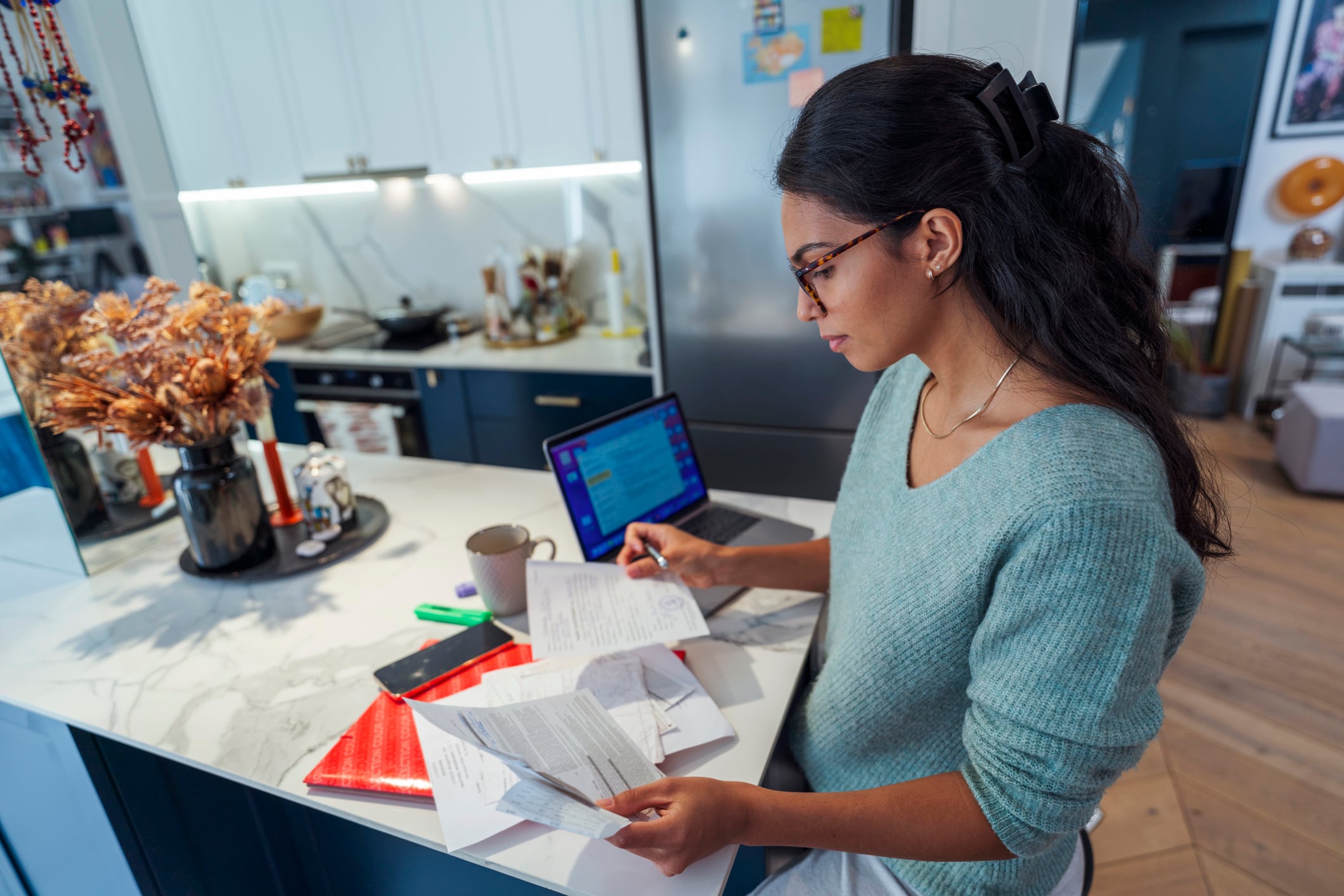 Female entrepreneur calculating expenses in cozy home interior